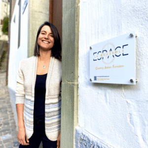 Portrait de Lisa Burri, fondatrice d’Espace La Boussole, debout devant l’entrée de son espace d’accompagnement à Fribourg. Cette image reflète l’accueil chaleureux et bienveillant réservé aux personnes en quête de clarté, de recentrage ou de mieux-être. Lisa y propose des accompagnements personnalisés en astrologie, Human Design, coaching de vie et nutrition, en présentiel à Fribourg ou en ligne. Cette photo illustre le lien humain et l’engagement dans un accompagnement sensible, concret et profondément aligné avec les besoins de chaque personne.