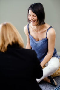 Lisa Burri souriante lors d’un coaching ou atelier de groupe, illustrant la relation positive avec ses clients.